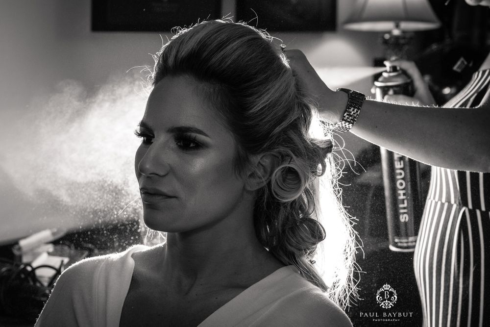 A hairstyling session in progress with dramatic backlighting creating a soft glow.