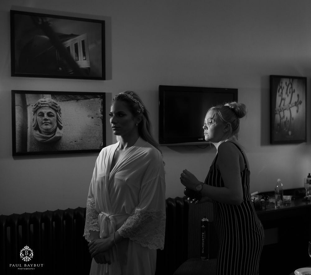 Black and white photo of a pre-event preparation scene with artwork visible on walls.