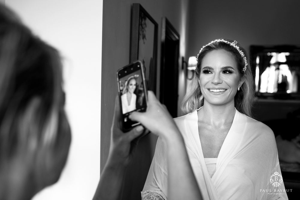 Black and white photo capturing a moment with a phone reflection in a mirror.
