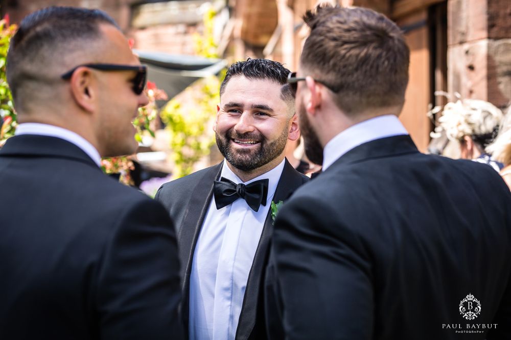 Groomsmen sharing a lighthearted moment during wedding festivities.