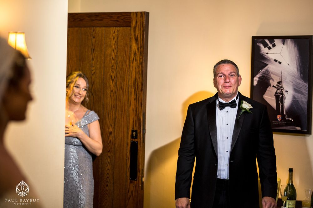 A first look wedding moment captured in an elegant room with warm lighting.