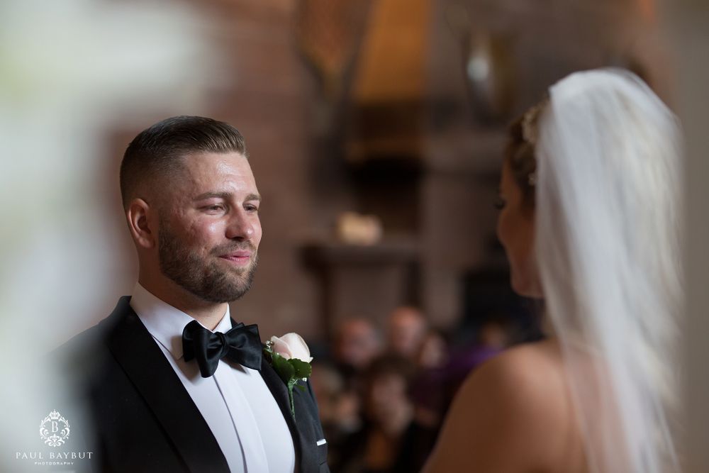 A wedding ceremony in progress with beautiful white floral decorations and candlelight.