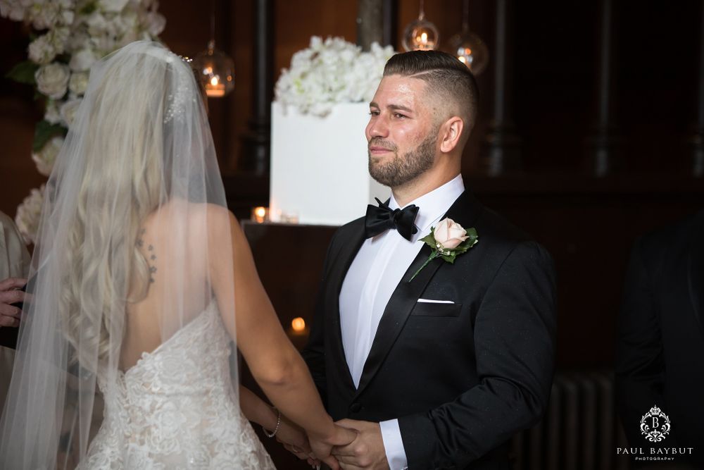 A romantic wedding ceremony moment with beautiful white floral arrangements and ambient lighting.