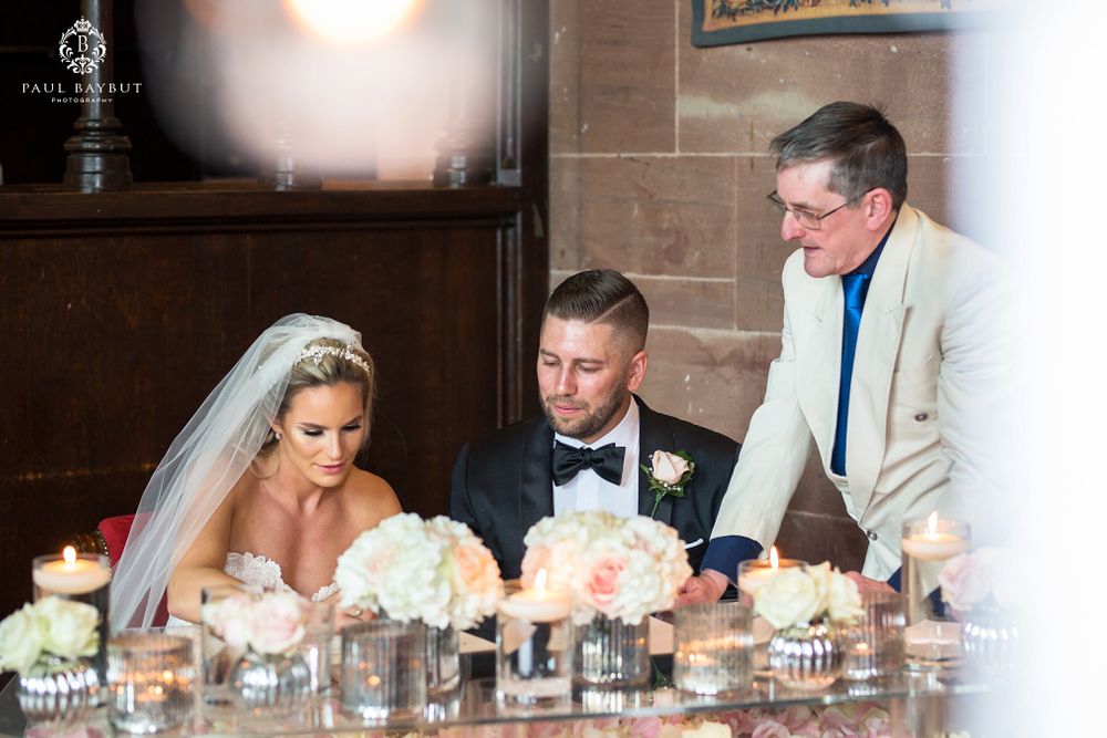 Elegant wedding reception table with white floral centerpieces and romantic candlelight.