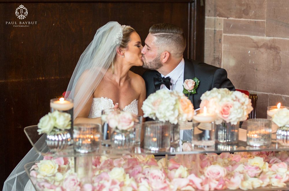 Romantic moment at wedding reception table decorated with pink and white flowers.