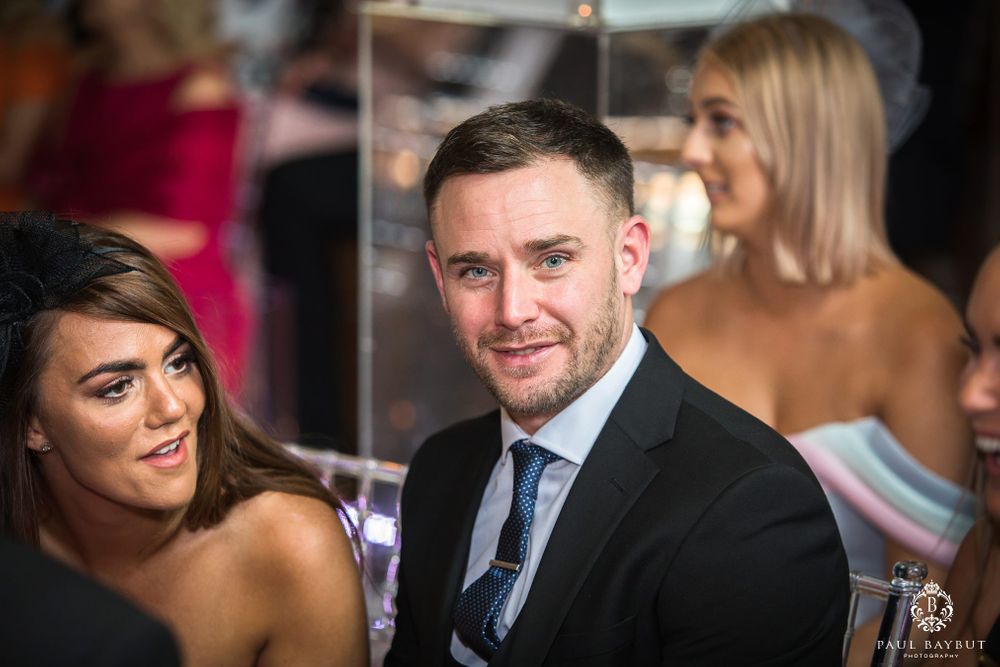 Wedding guests enjoying conversation at formal reception event.