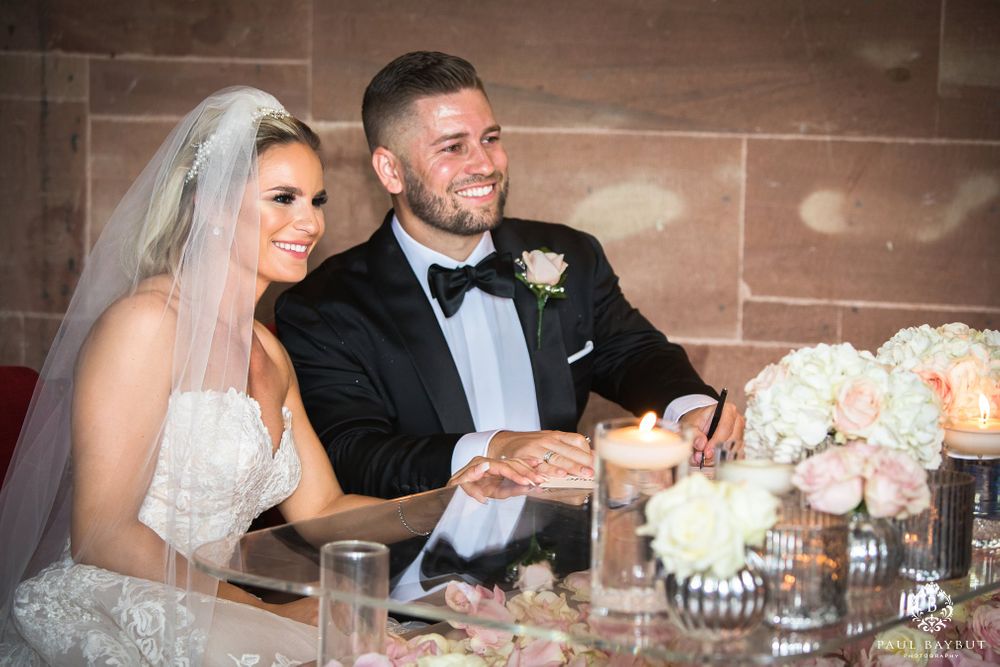 Bride and groom share moment at reception table decorated with candles and flowers.