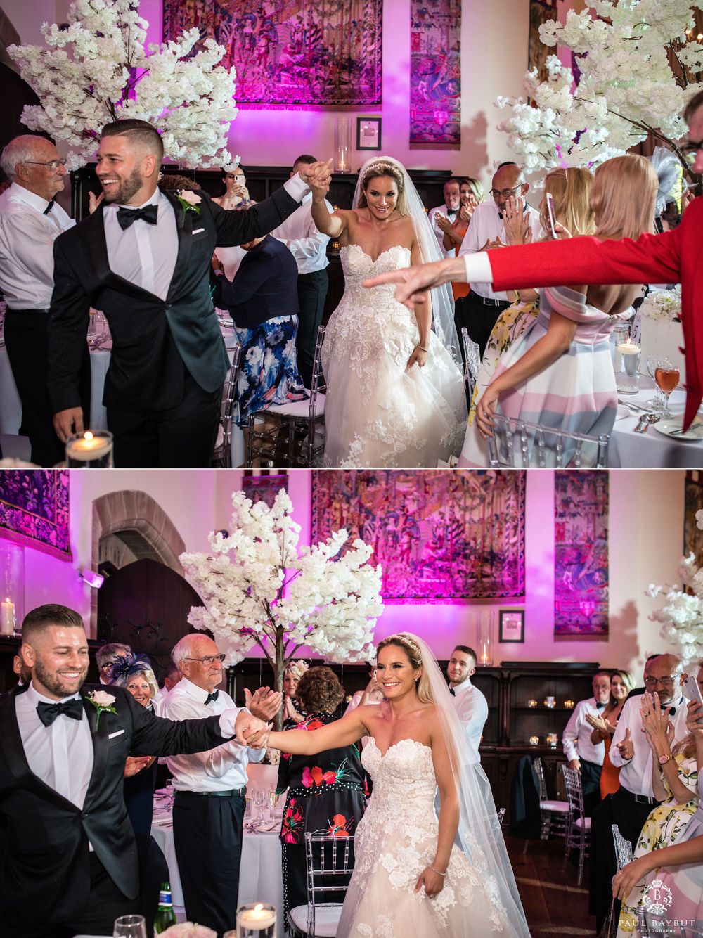 Lively wedding reception celebration with guests dancing among decorative white trees and purple lighting.