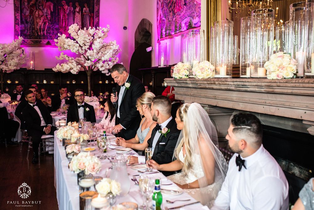 Formal wedding reception dinner with chandelier lighting and elegant table decorations.