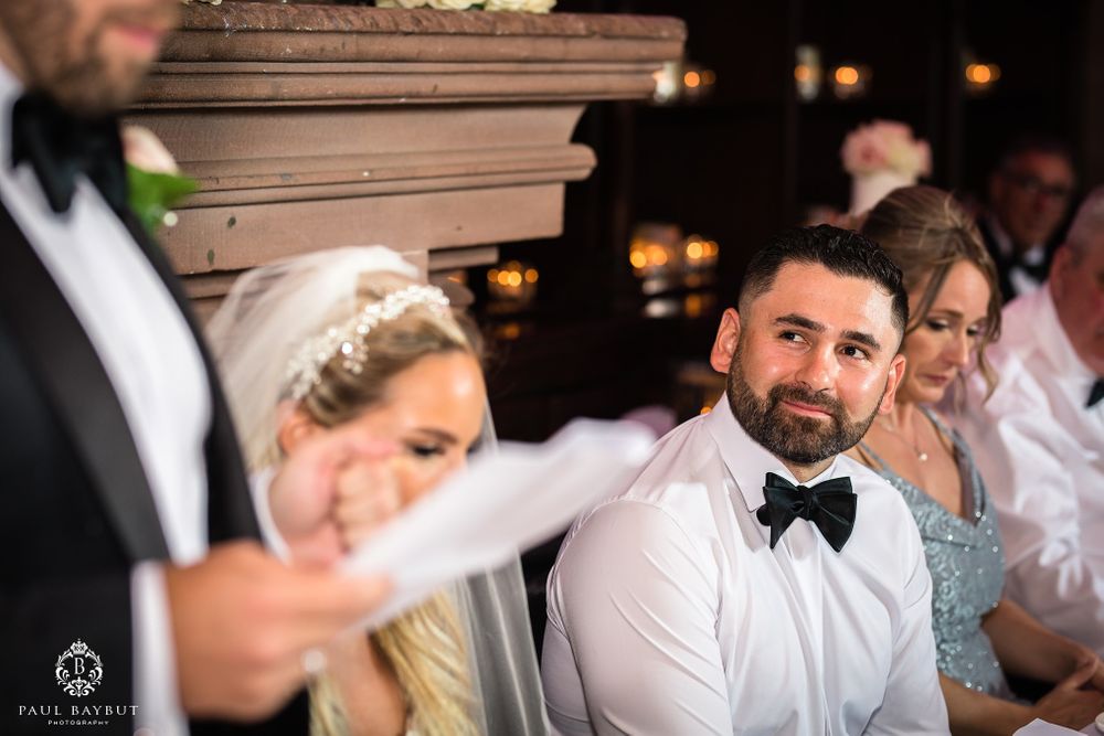 Wedding party members listen attentively during speeches at an elegant reception.