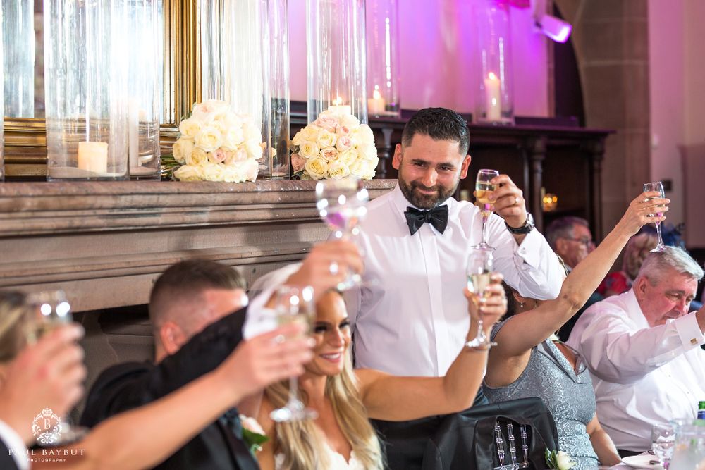 Wedding guests raise their glasses in a festive toast during the reception celebration.