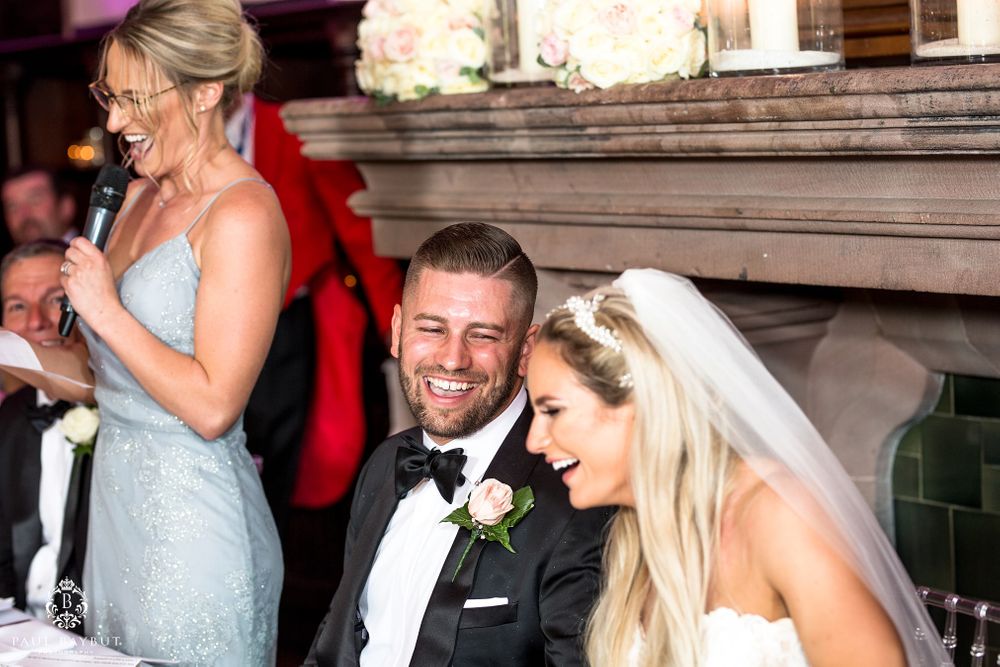 Wedding party members share a joyful moment during reception speeches and toasts.