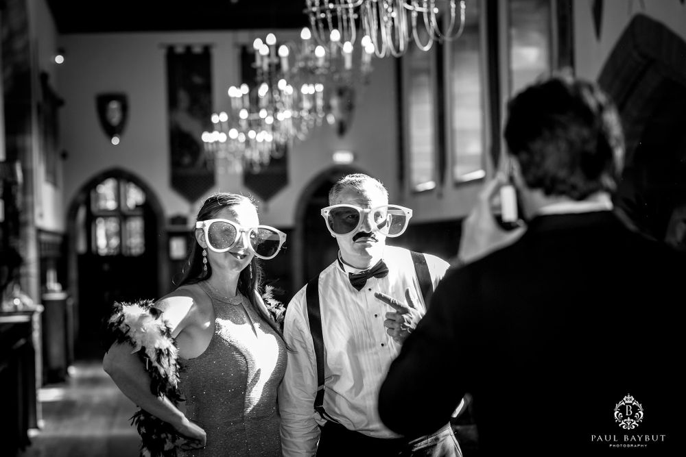 Black and white photo of guests wearing novelty glasses at a wedding celebration.