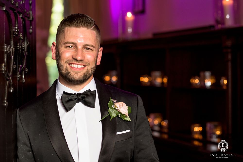 Portrait of a person in formal black tie attire with boutonniere at an evening event.