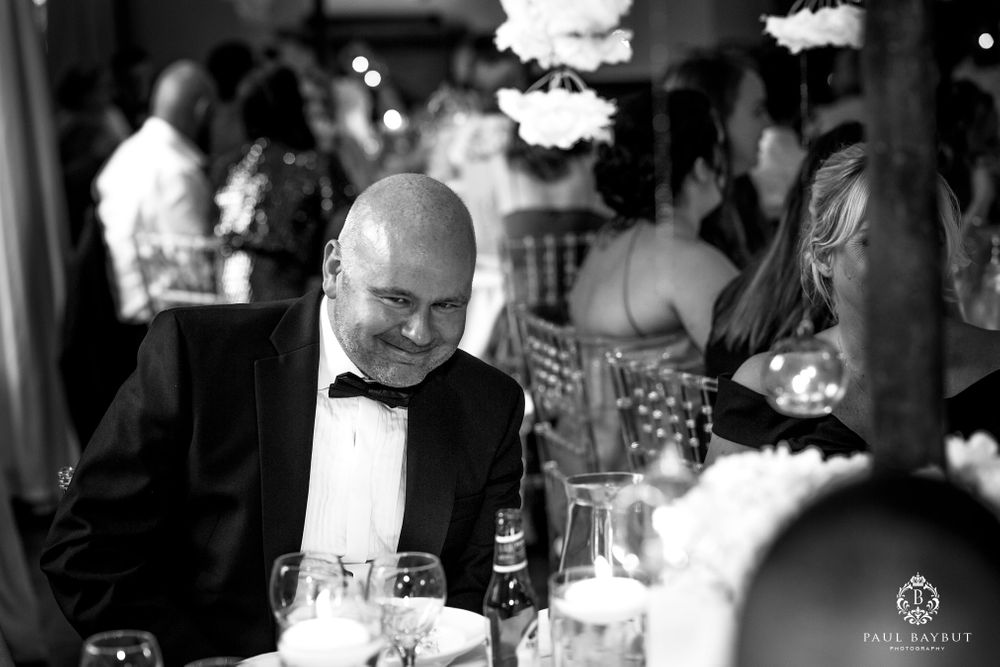 Black and white candid photo of a guest at a formal dinner reception.