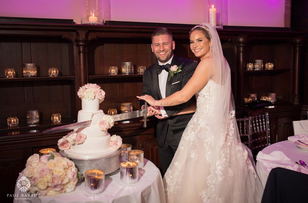 Couple performs traditional cake cutting ceremony at their wedding reception.