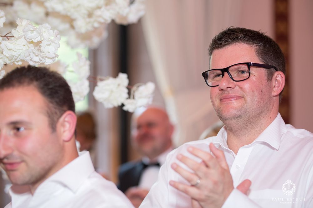 Wedding guests applauding during reception celebration.
