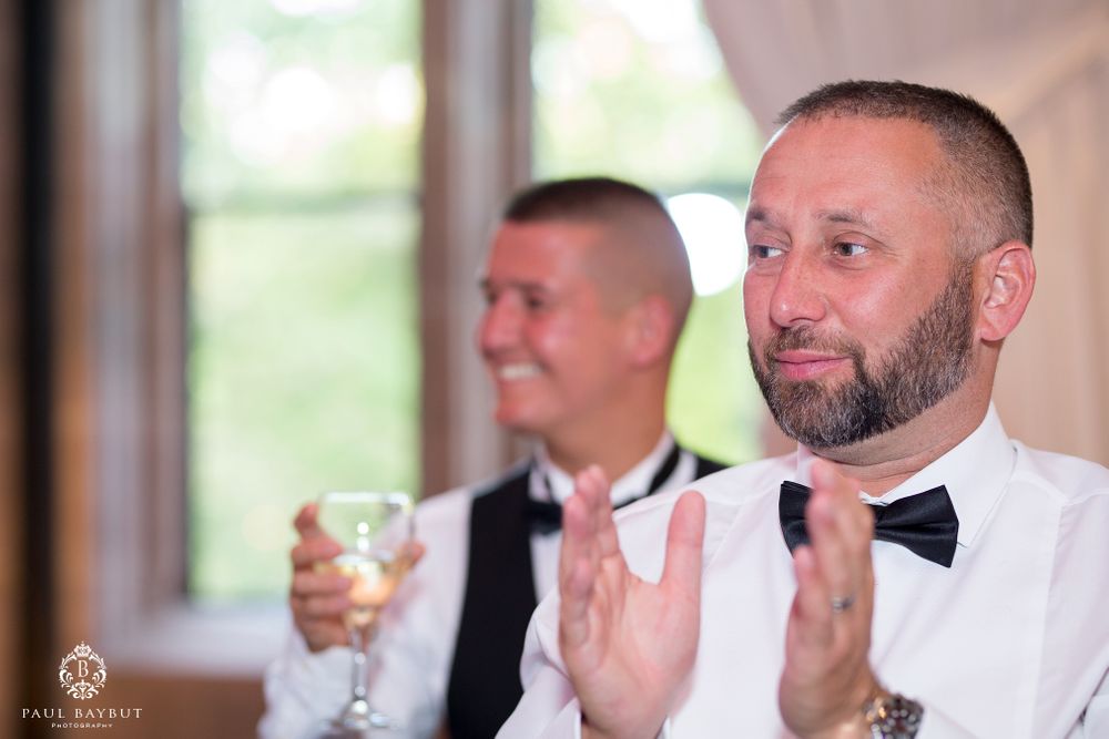 Guests applauding during wedding reception festivities.