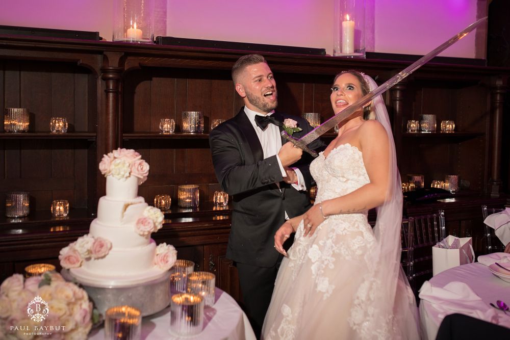 Couple celebrating with champagne during wedding cake cutting ceremony.