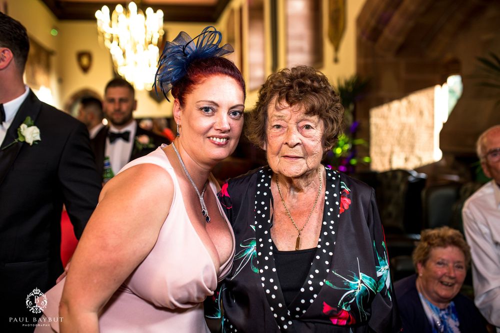 Wedding guests in evening wear share a warm moment during the reception celebrations.