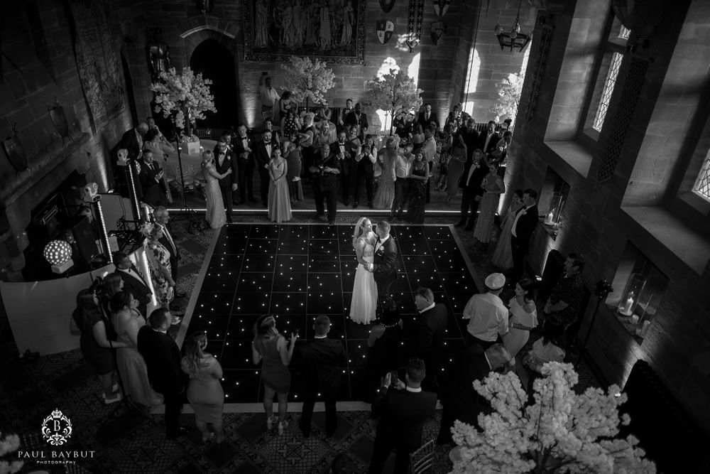 Overhead black and white view of wedding reception dance floor surrounded by guests.
