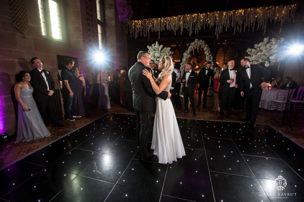 Wedding couple dances on a starlit floor beneath elegant hanging decorations.