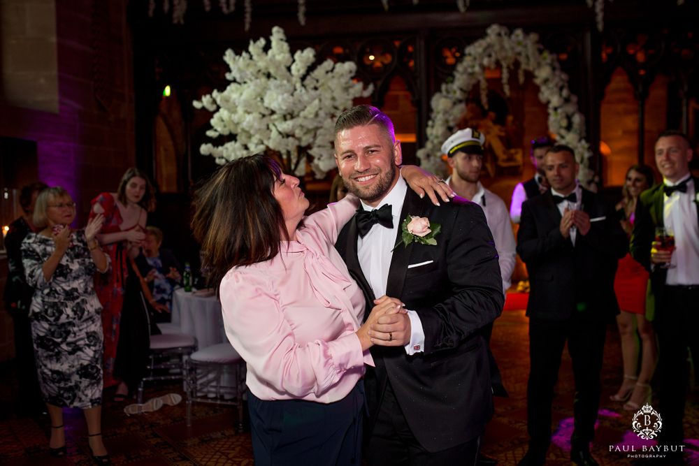 Wedding celebration featuring a dance performance on an elegant dance floor with white floral decorations.