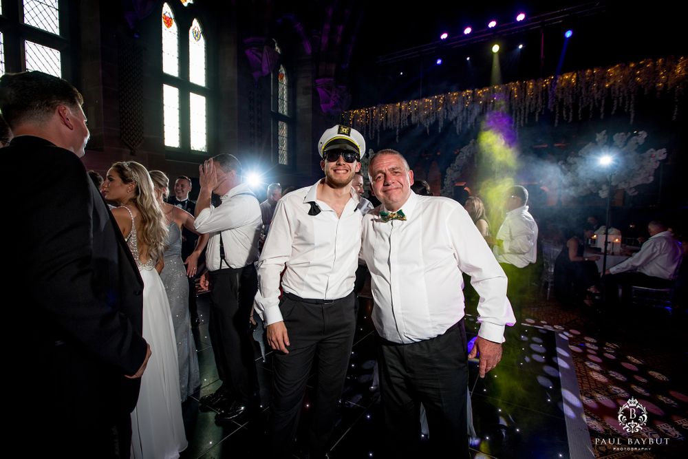 Wedding celebration captured with dramatic lighting and fog effects on the dance floor.