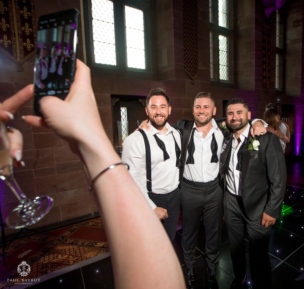 Wedding party members pose for a photo in black and white formal attire.