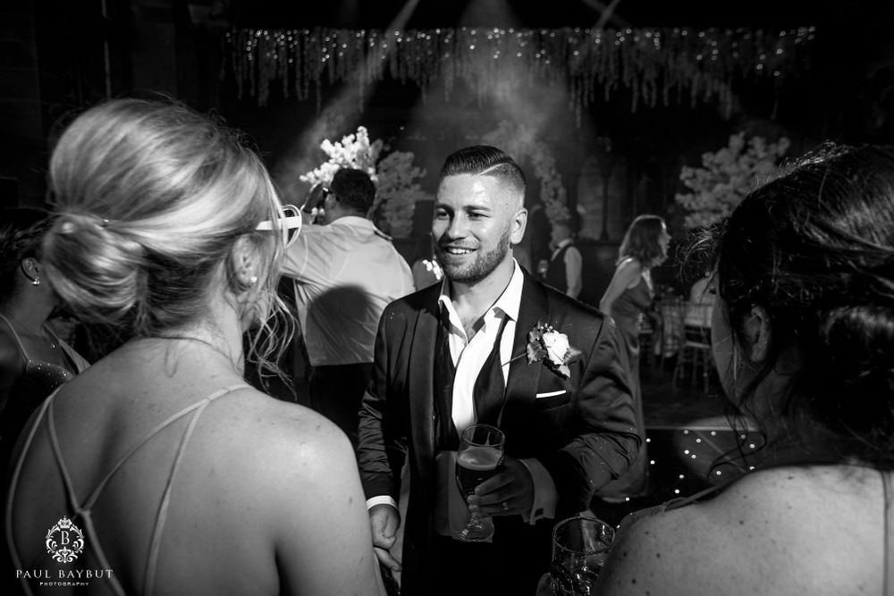 Elegant black and white candid moment captured during wedding reception celebration.