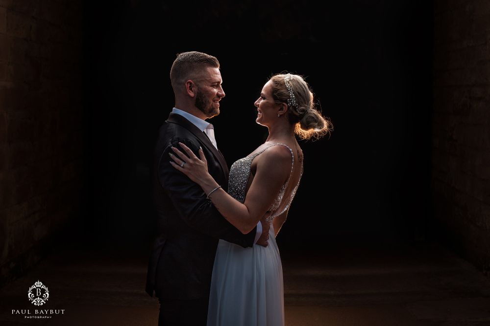 Intimate couple's dance captured in dramatic dark setting.