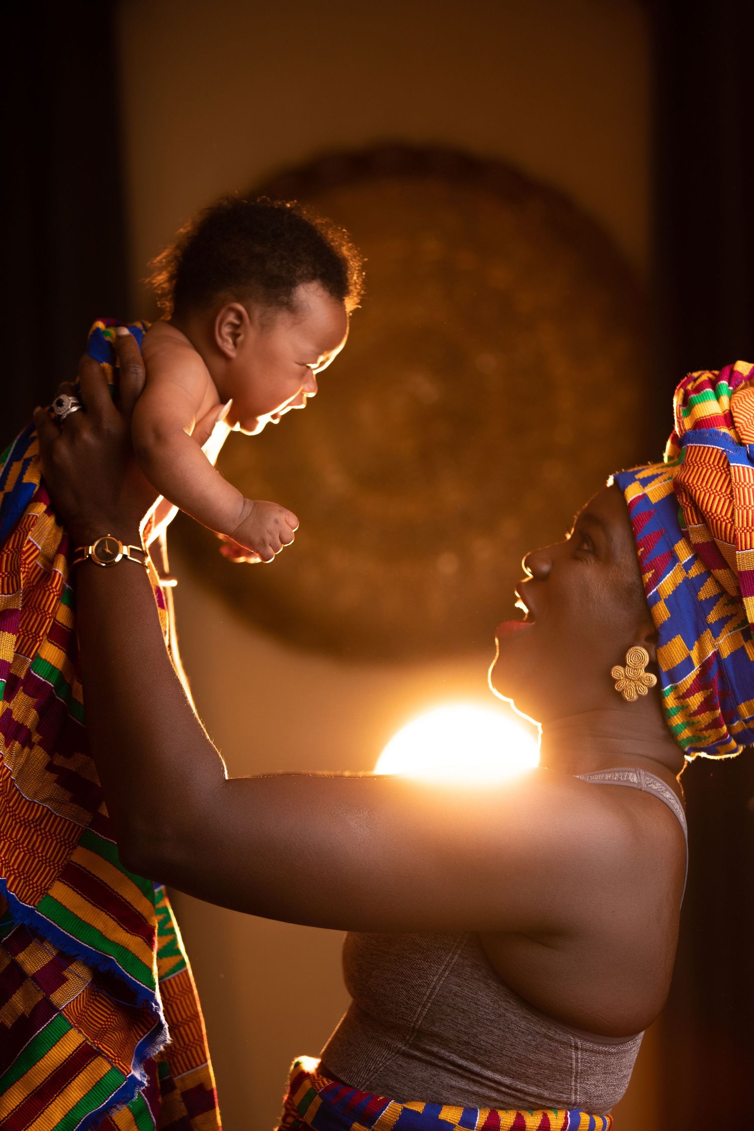 Dramatic sparkler photo series showing colorful traditional African dress in warm lighting.