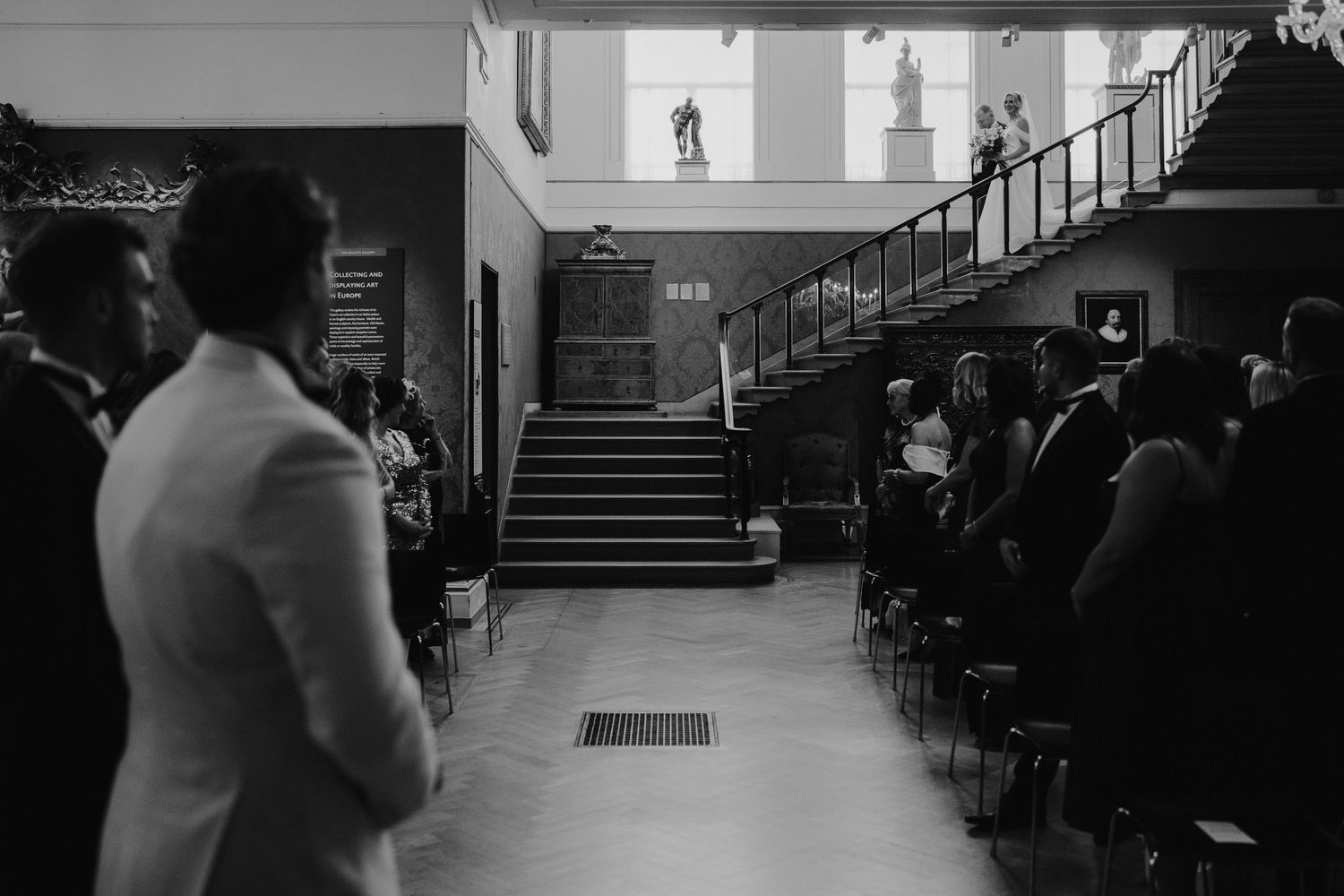 bride and groom descending stairs at the European art gallery to meet the groom at the alter at the ashmolean museum