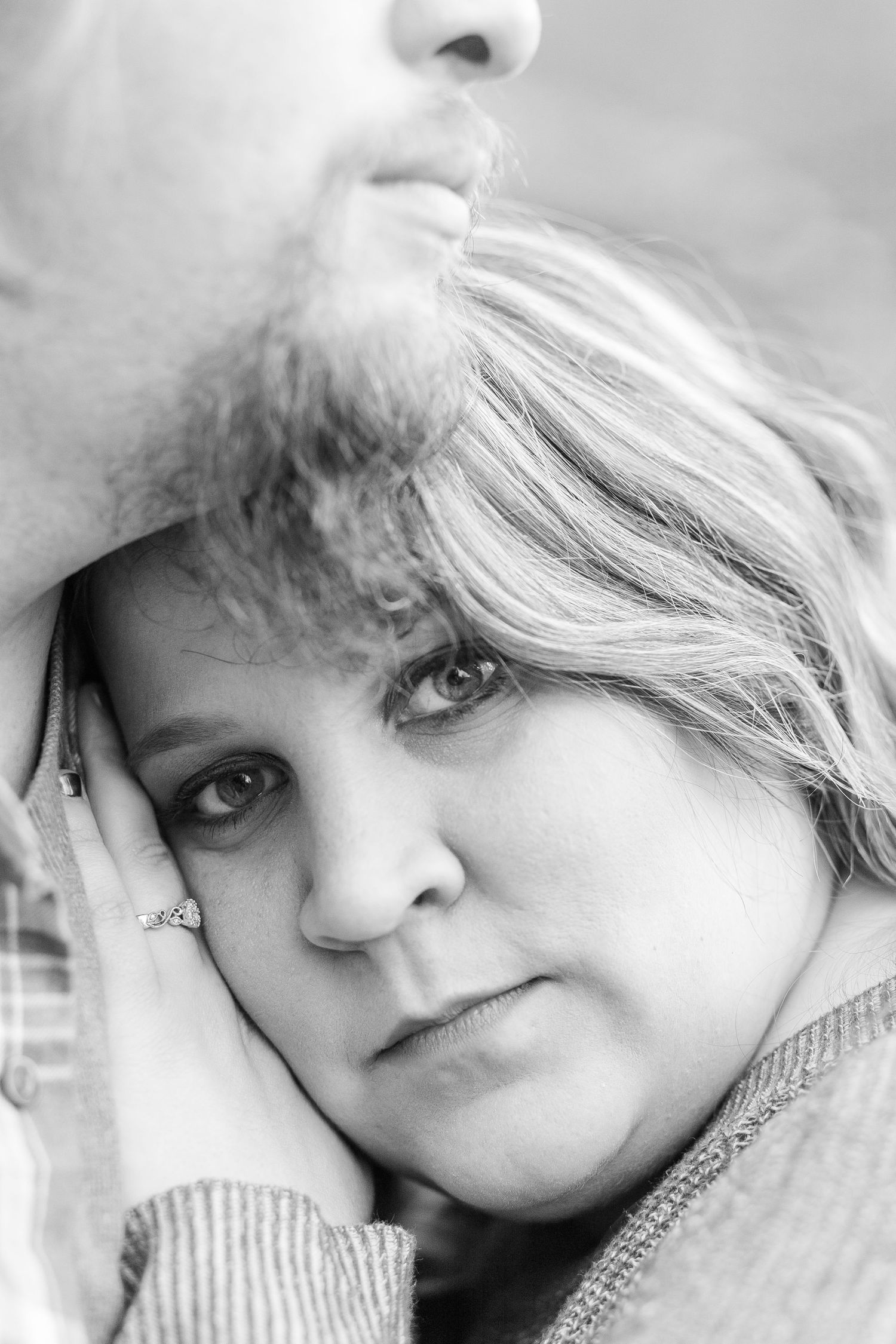 A close-up black and white portrait showing tender intimacy between two people.