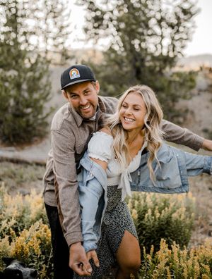 Playful moment captured in mountain meadow with wildflowers.
