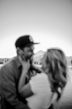 Black and white artistic portrait of couple by mountain lake.