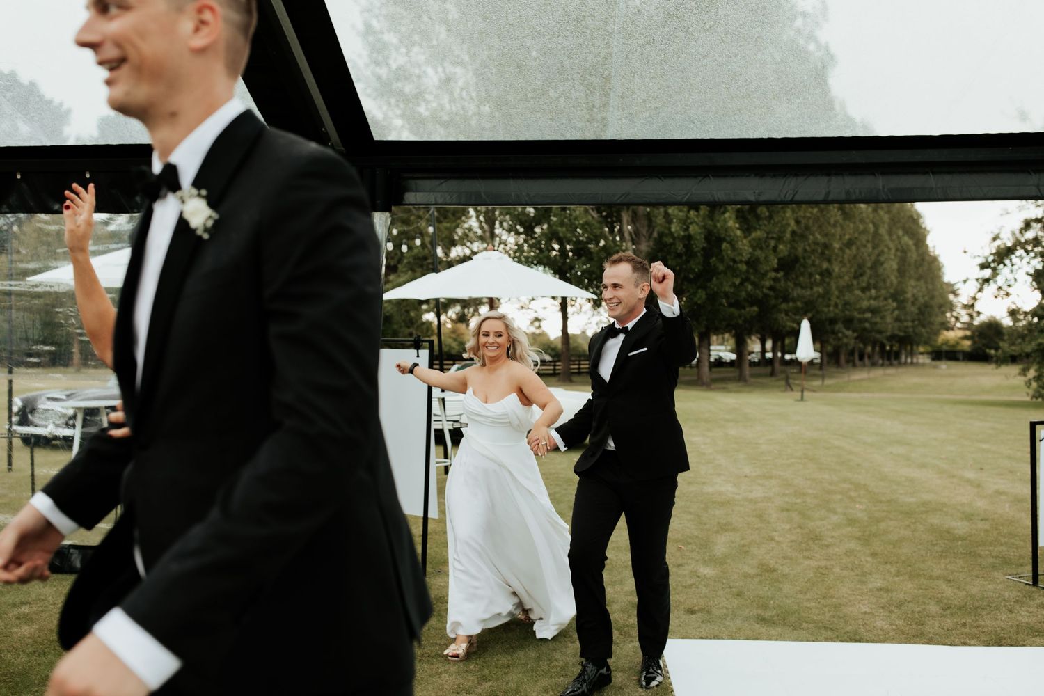 Classic black and white wedding attire contrasts with a lush outdoor garden setting during a joyful ceremony.