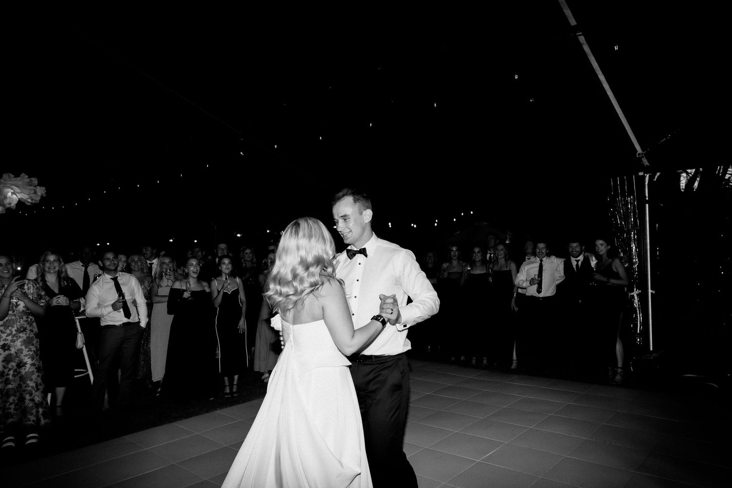 Black and white photo of couple sharing their first dance at wedding reception.