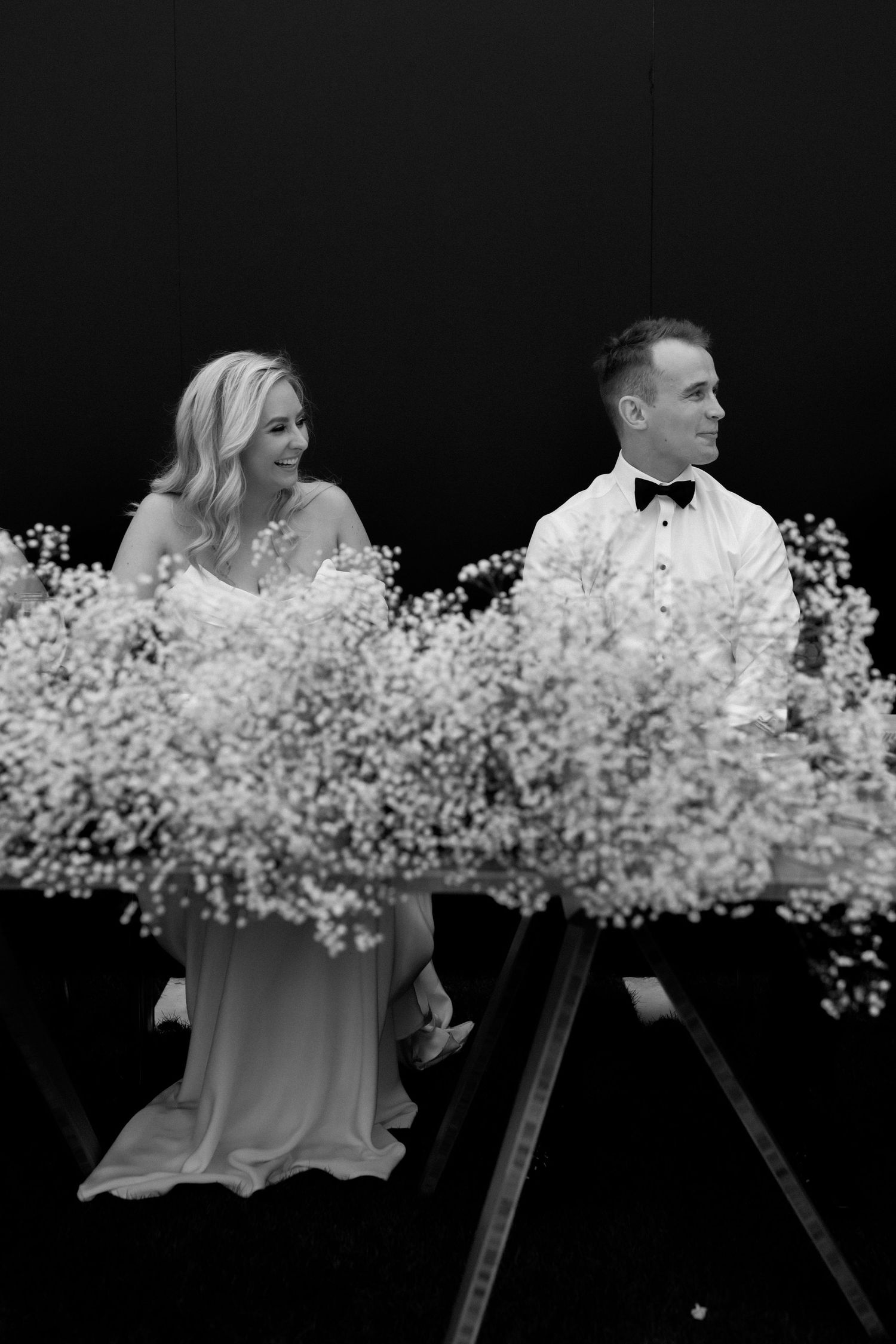 Elegant black and white portrait with baby's breath floral arrangements at a wedding.