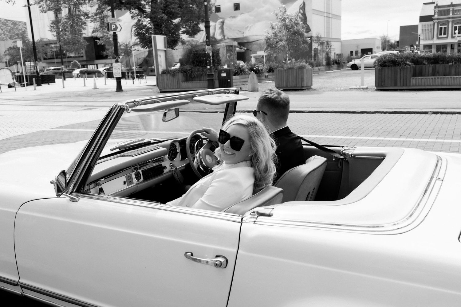 Couple sharing romantic moment in classic white convertible car.