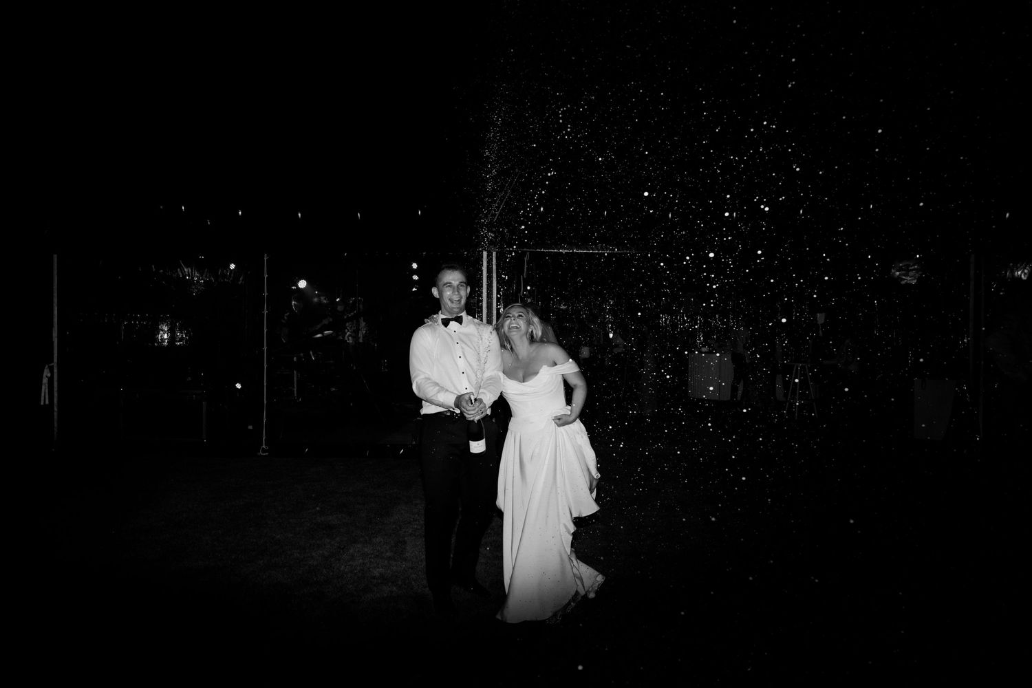 A black and white portrait of a couple dancing in an intimate nighttime setting.