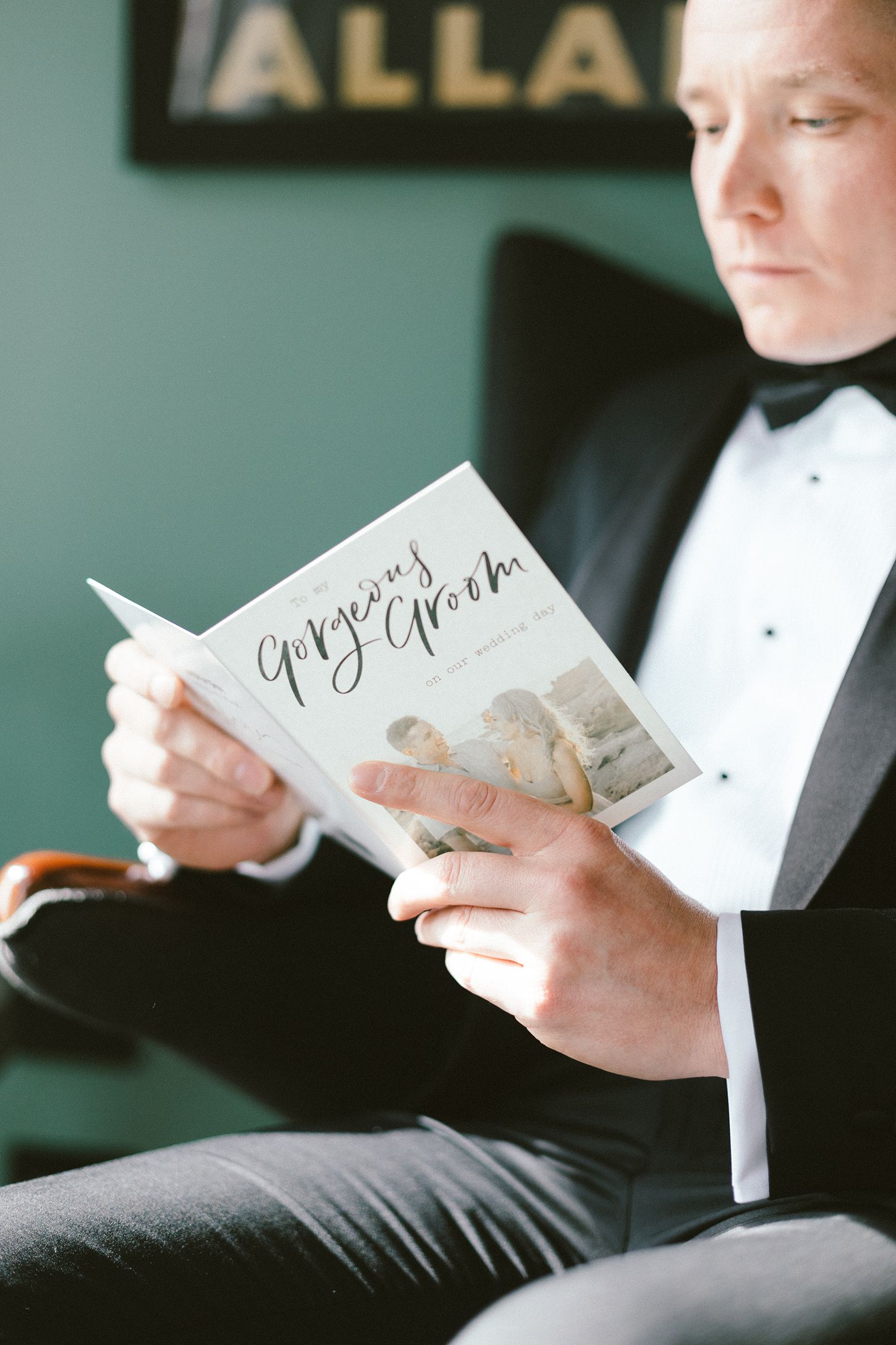 Close-up of hands holding an elegant wedding vows book with handwritten text.