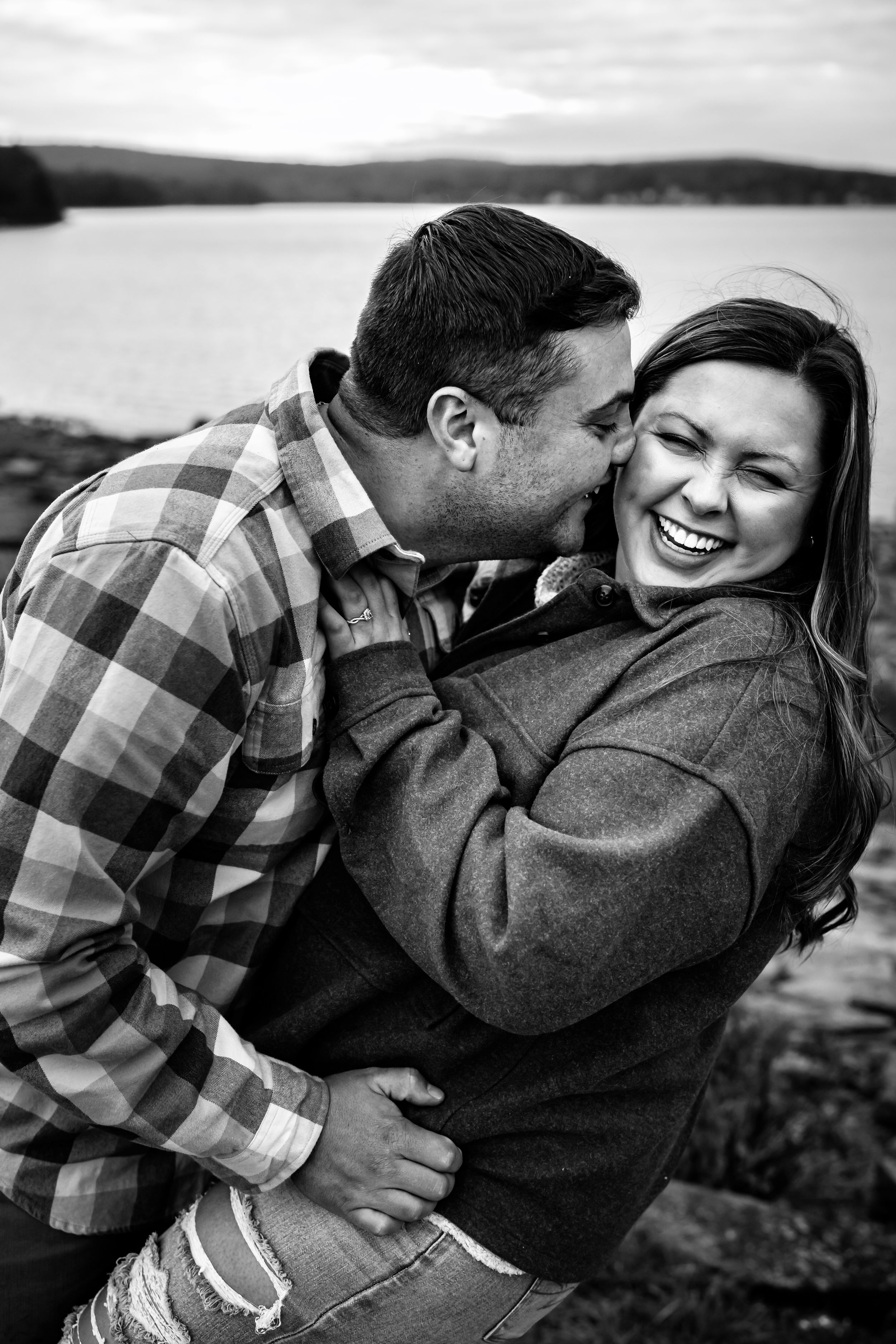 Black and white photo of a playful moment between two people outdoors.