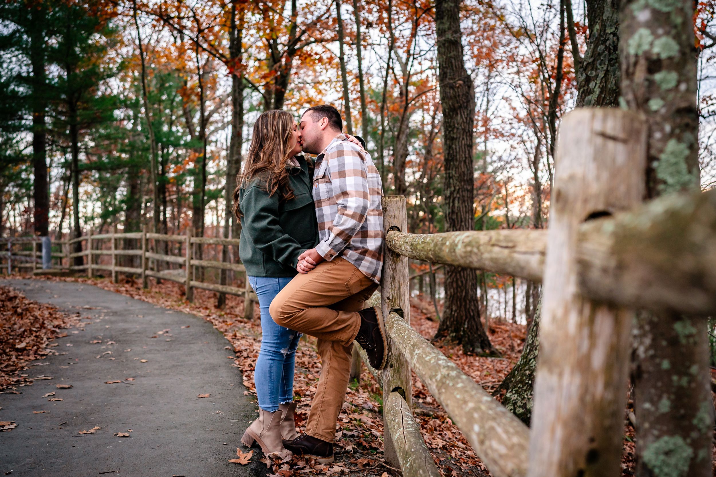 Fall foliage frames a path along the water's edge with warm autumn colors.