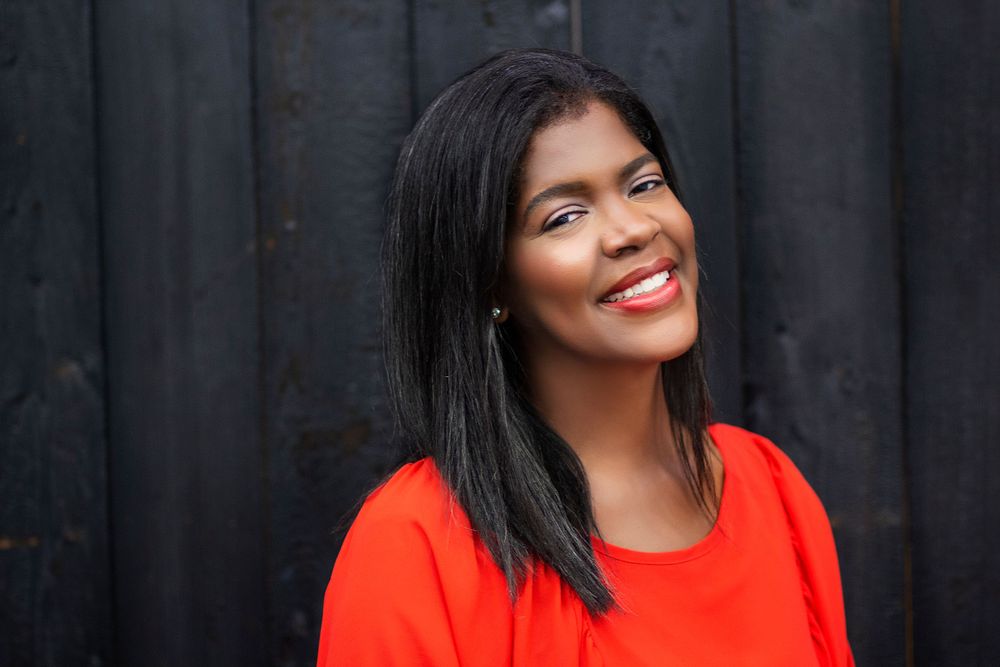 Professional portrait series showing joyful expressions in bright red top against dark background.