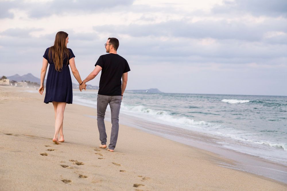 couple walking on beach looking at each other