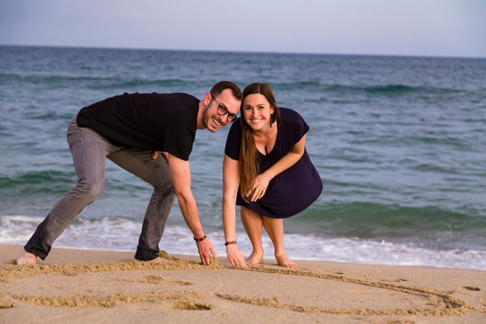 couple drawing a heart in the sand