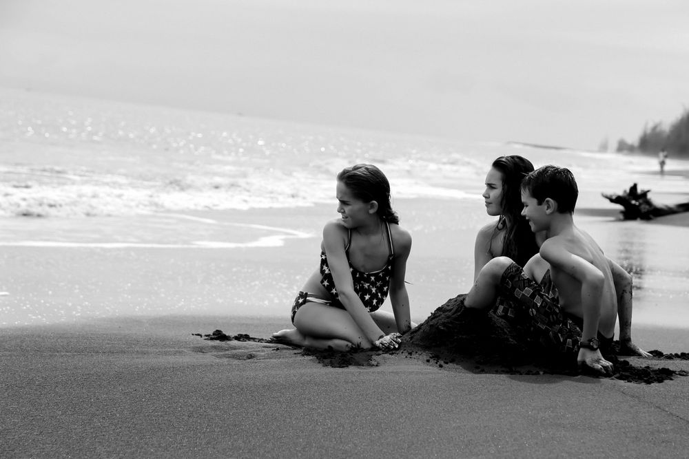 the kids playing in the sane on a beach in Hawaii