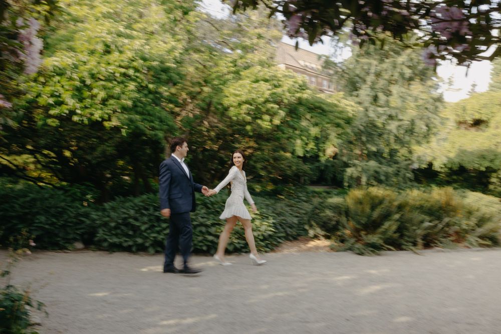 A romantic stroll along a garden path surrounded by lush greenery and trees.