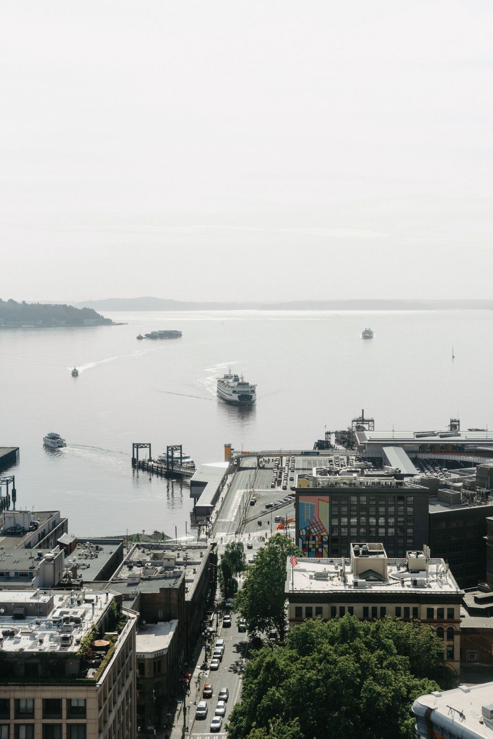 Aerial view of a harbor with boats and buildings along the waterfront on a misty day.